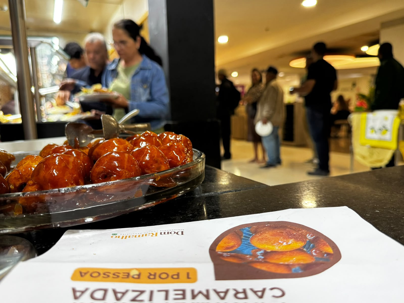 Ambiente do Dom Ramalho com sobremesa e movimento da praça de alimentação